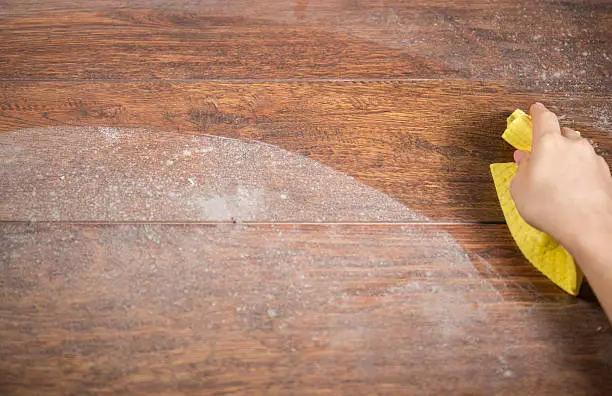 Wiping dusty wood using yellow rag