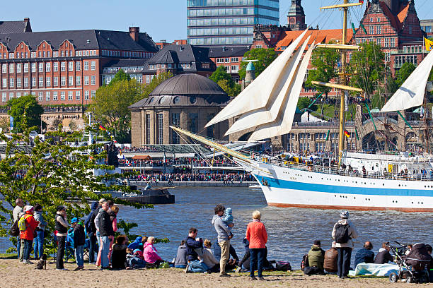 Hamburg, Germany - May 10, 2015: Hamburg harbor birthday celebration (Hafengeburtstag). One million visitors from around the world joined the world’s greatest port festival. Parade in front of the Landing Stages (Landungsbrücken), featuring more than 300 ships. Historical Russian training ship MIR with visitors in front.