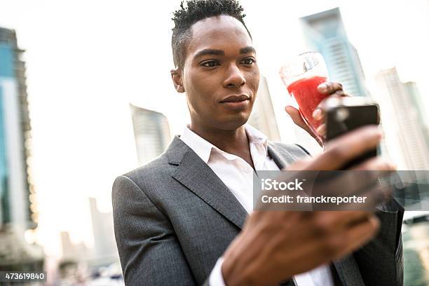 Elegant Businessman Drinking An Orange Juice In Dubai Marina Stock Photo - Download Image Now