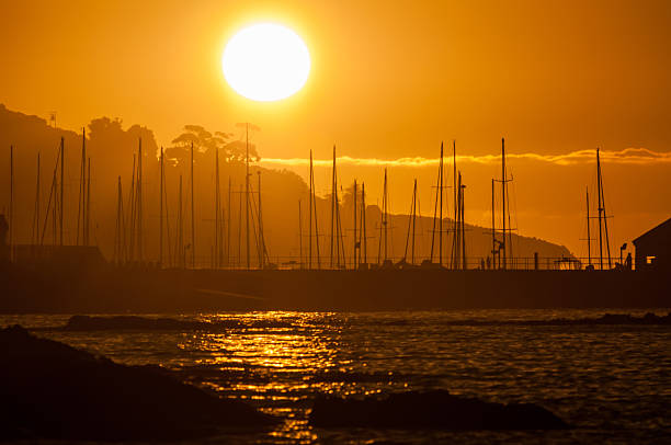Silhouette of ships masts against sunset Silhouette of ships masts against sunset over the Gordons Bay harbor in the Western Cape Province of South Africa gordons bay stock pictures, royalty-free photos & images