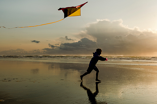 A boy flies a kite near sunset on the beach in Newport, Oregon.