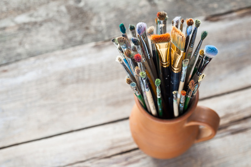 Used painter paintbrushes in a jug from potters clay