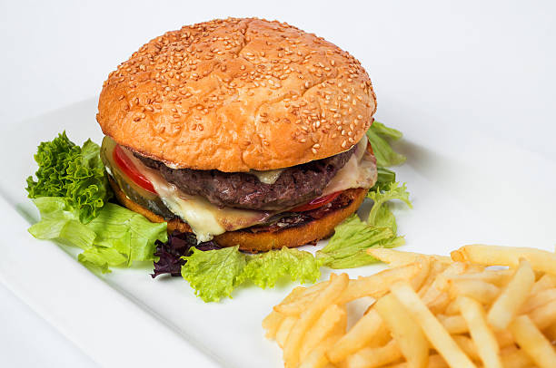 istock Tasty cheeseburger with fried potatoes, isolated on white 473630624