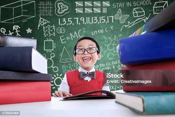 Asian Boy Laughing In Class With Stack Of Books Stock Photo - Download Image Now - Child, Genius, 2015