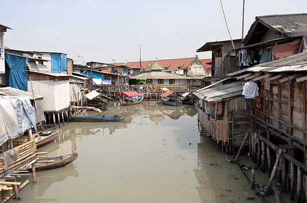 Slum in Jakarta Slum on dirty canal in Jakarta, Indonesia jakarta slums stock pictures, royalty-free photos & images