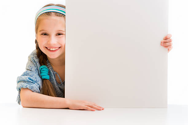 istock cute little girl holding a white board 473642868