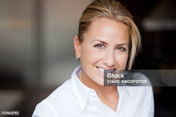 Portrait Of A Mature Blond Woman Smiling At The Camera Stock Photo - Download Image Now