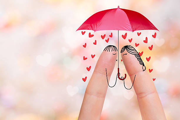istock Lovers are kissing under umbrella with falling hearts 473645978