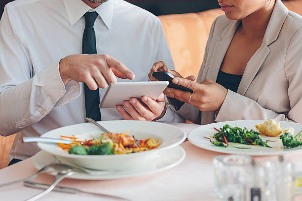 istock Business people using smart phone and digital tablet at lunch 473656772
