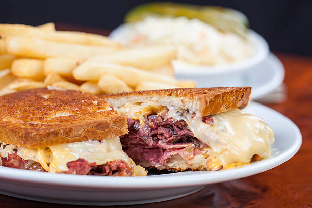 Ruben sandwich with corn beef and melted cheese on toast New York style ruben sandwich with corn beef, saurkraut and melted cheese on toast served on plate with french fries pastrami stock pictures, royalty-free photos & images
