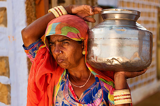 istock Indian woman carrying water from well 473659770