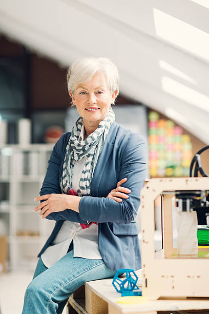 istock Mature Woman Working By 3D Printer in New Startup Office. 473659918