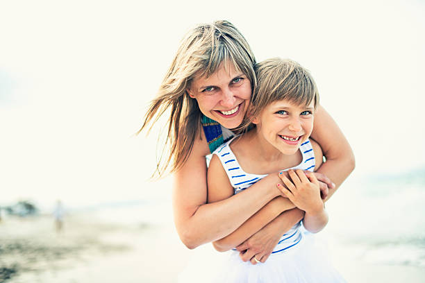istock Mother and daughter hugging on the beach 473660772