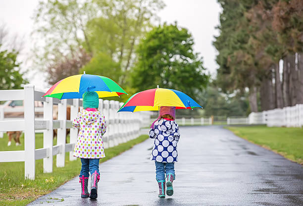 istock Two Young Girls Walking With Umbrellas on Ranch 473663406