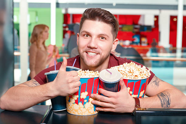 istock Young man buying popcorn and coke 473666438