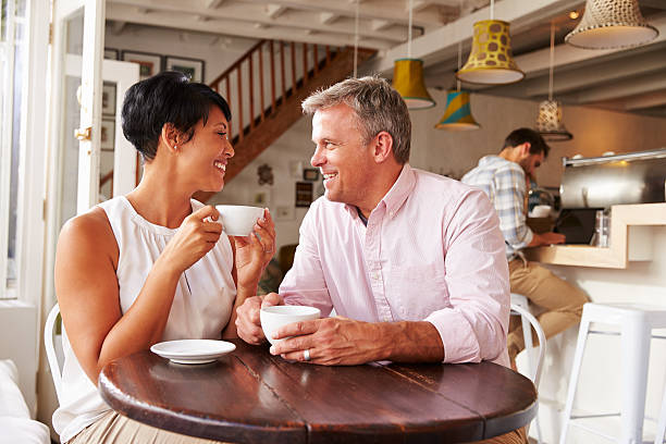 中央のアンティーク風のカップルには、カフェのコーヒーをお楽しみいただけます。 - two people business lunch multi ethnic group meeting ストックフォトと画像