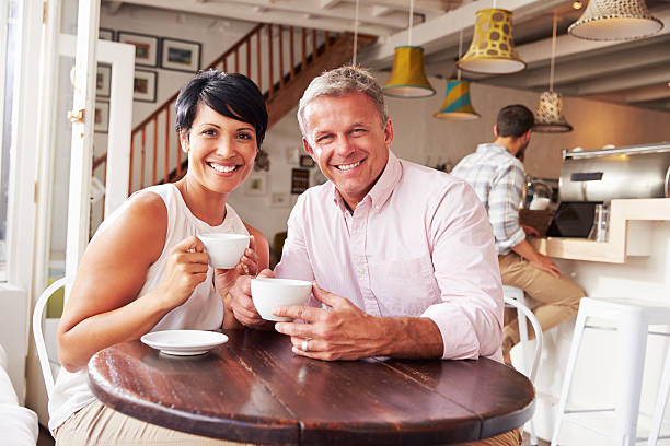 istock Middle aged couple enjoying a coffee in a cafe 473668974
