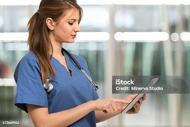 Nurse Using A Digital Tablet Stock Photo - Download Image Now - 2015, Adult, Assistance