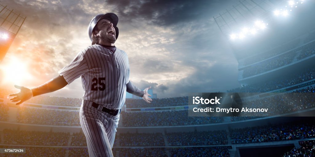 Baseball player in stadium A male baseballs batter makes a dramatic play.  The stadium is blurred behind him. Only the lights of the stadium shine brightly, creating a halo effect around the bulbs. 16-17 Years Stock Photo