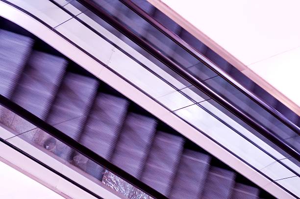abstrato vista de roxo escadas rolantes - escalator automated built structure moving down - fotografias e filmes do acervo