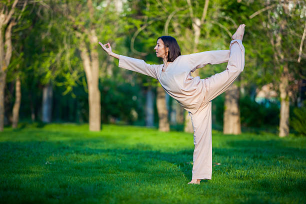 istock Practicing yoga in the morning, with trees  background 473675942
