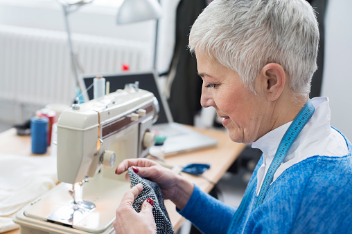 Seamstress sewing in her fashion studio