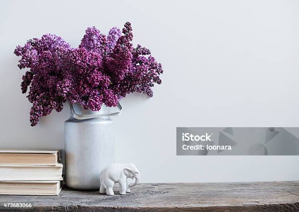 Purple Flowers In A Vintage Milk Tin With Porcelain Elephant Stock Photo - Download Image Now