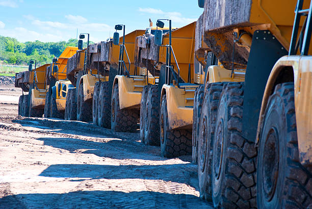 fila de descarga de camiones en dirección a través de la construcción de la zona - convoy fotografías e imágenes de stock