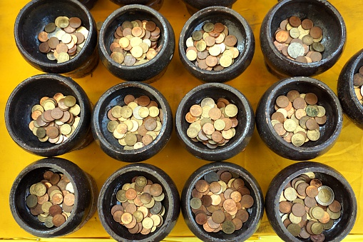 donate Thai coin in Buddhist monk's alms bowl for good luck