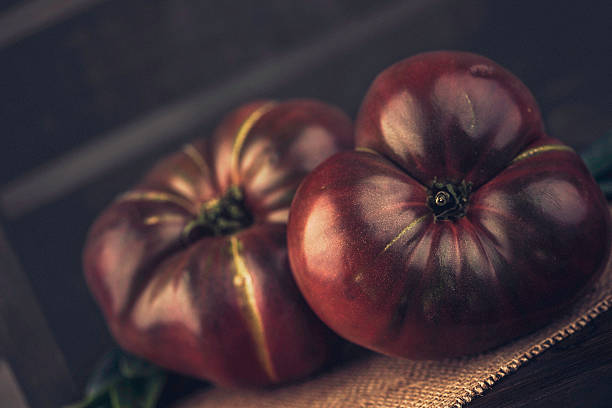 bio frais de l'intérieur les tomates d'héritage dans caiss'en bois.   alimentation saine. - heirloom tomato food tomato crate photos et images de collection