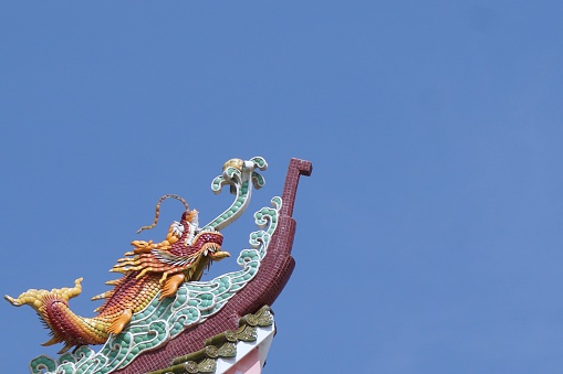 dragon fish stucco on the rooftop with blue sky background