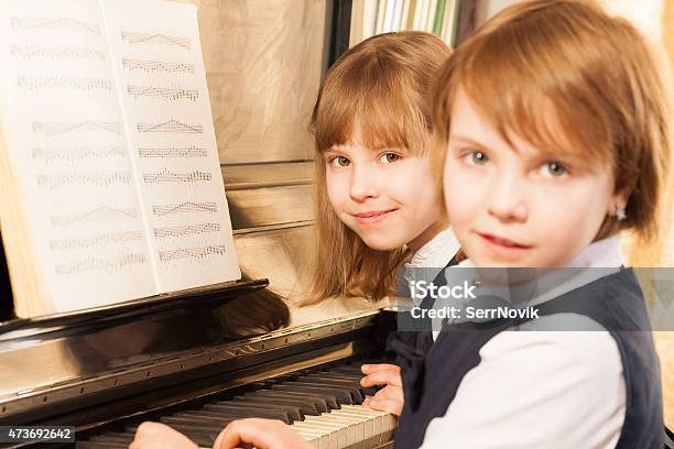 Smiling Beautiful Small Girls Playing Piano Stock Photo - Download Image Now - 2015, Art, Beautiful People