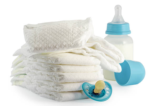 A stack of baby diapers bottle and a pacifier