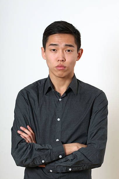 istock Romantic young Asian man with crossed hands looking at camera 473698596