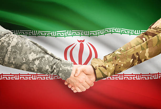 istock Men in uniform shaking hands with flag - Iran 473702204