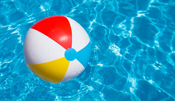 istock Beach ball party in a blue water swimming pool 473703684