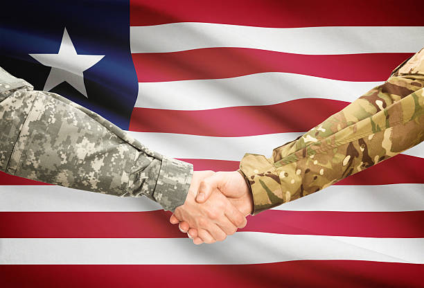 istock Men in uniform shaking hands with flag - Liberia 473706630