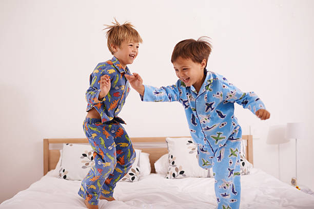 We've got the moves likes jagger Shot of two little boys jumping on the bedhttp://195.154.178.81/DATA/i_collage/pi/shoots/783640.jpg pyjamas stock pictures, royalty-free photos & images