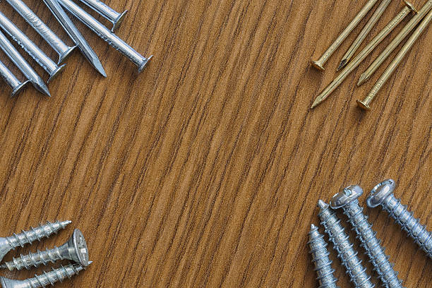 istock Nails and screws on a wooden background with copy space 473712478