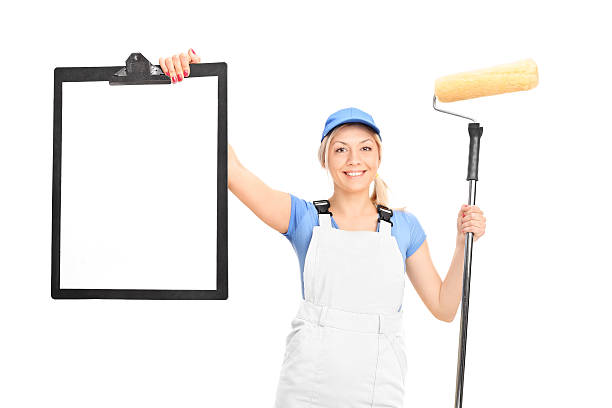 istock Female painter holding paint roller and a clipboard 473712774