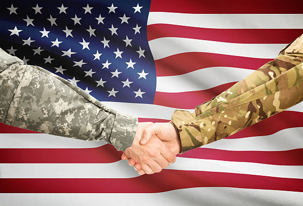 istock Men in uniform shaking hands with flag - United States 473712946
