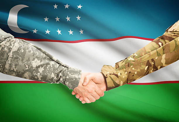 istock Men in uniform shaking hands with flag - Uzbekistan 473712958