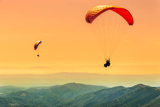 duo gleitschirmfliegen flug - gleitschirmfliegen stock-fotos und bilder