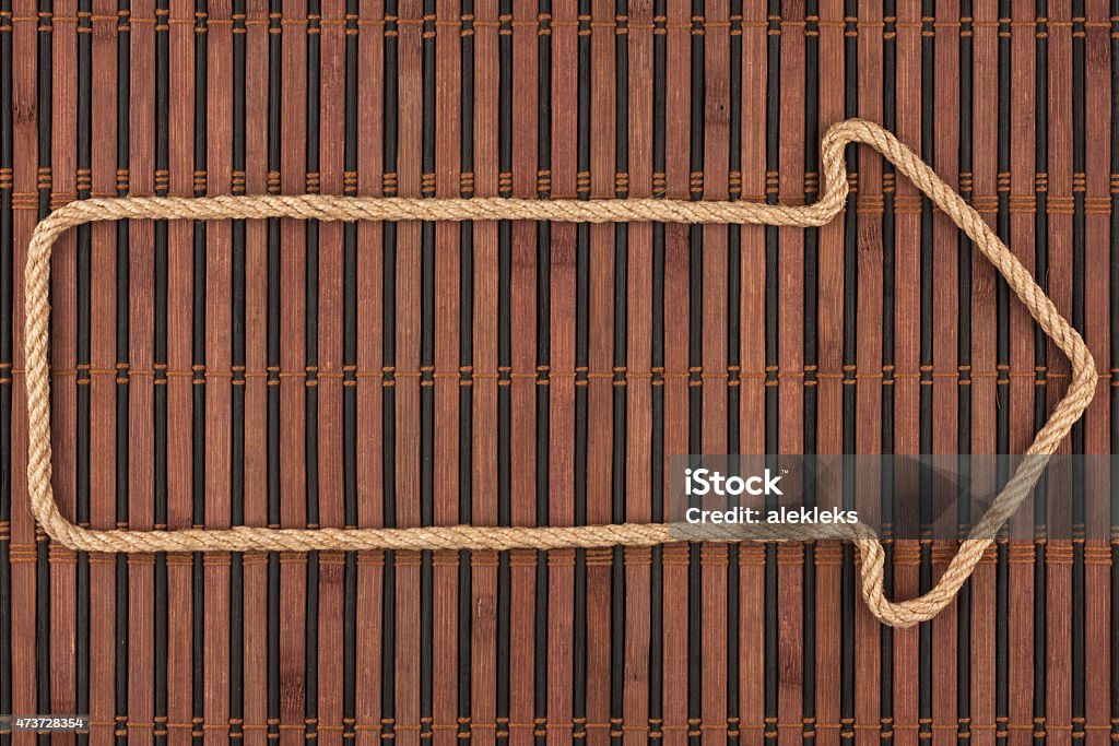 Arrow made of rope  lies on a bamboo mat Arrow made of rope  lies on a bamboo mat, can be used as background, texture 2015 Stock Photo