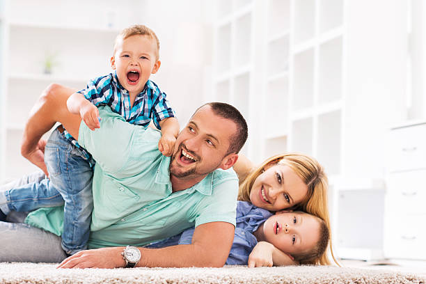 istock Cheerful family having fun on carpet at home. 473734982