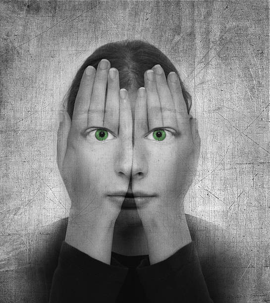 Woman covers her face with hands and green eyes Woman covers her face with her hands and green eyes on the grunge backround. Phobia stock pictures, royalty-free photos & images