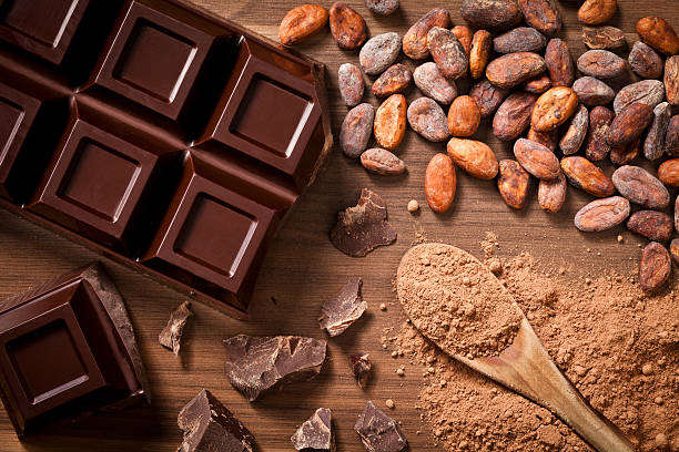 istock Chocolate bar, cocoa beans and ground cocoa shot directly above 473741340