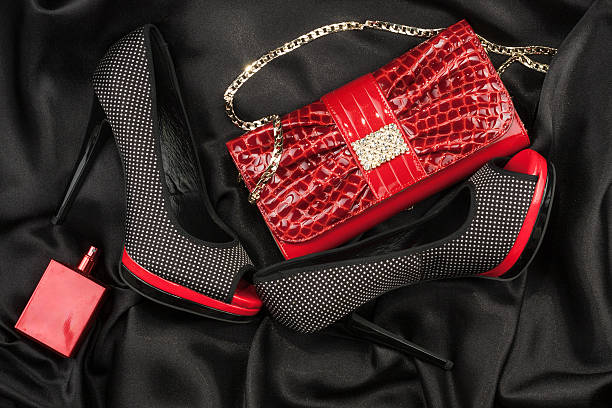istock Red bag, shoes and perfume lying on black satin 473742286
