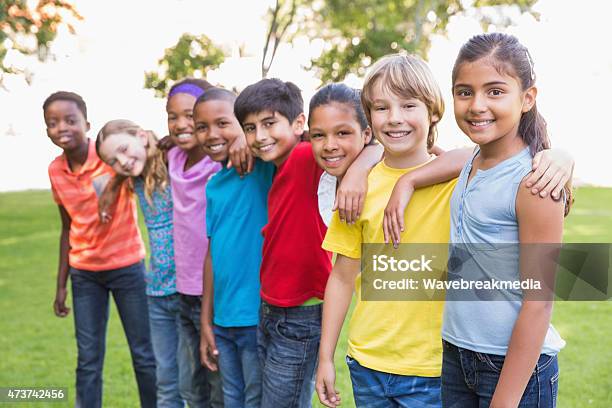 Happy Friends In The Park Stock Photo - Download Image Now - Child, In A Row, Arm Around