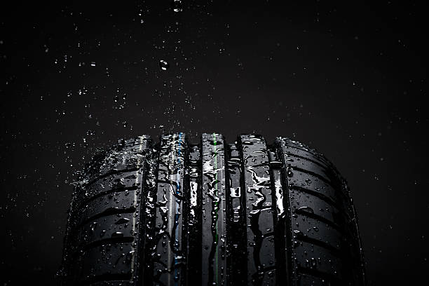 istock Water splashing on a new symmetrical tire during the rain 473745714